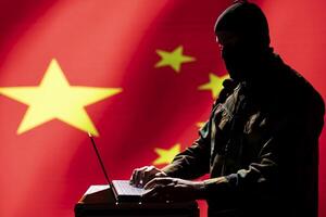 Chinese terrorist using software algorithms on laptop to do fundamentalism propaganda on internet. CCP government secret agent wearing mask sharing dangerous illegal malware online photo