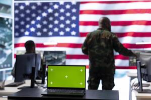 American army working in a command post with green screen, soldiers examining satellite imagery for clues regarding a national safety operation. US military control tower for surveillance. photo