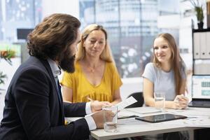 Financial advisor calculating clients net worth, taking count of assets and liabilities. Consultant in office helping customers decide how much money to invest, developing budget photo