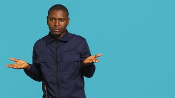 Portrait of security agent doing thumbs down sign gesturing, refusing entry while securing assigned post, studio background. Guardian doing negative hand gesture, handling security breaches, camera A photo