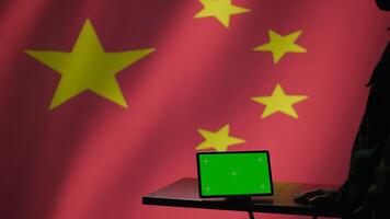 Chinese intelligence agency operator using green screen tablet to do mass propaganda on internet. CCP government secret agent engaging in psychological operations with mockup device, camera B photo
