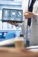 In a treatment center, healthcare experts discuss recovery strategies. Licensed doctors analyze heart and brain x rays from hospital records, focusing on diagnostics and disease prevention. photo