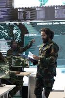 Special operations engineer analyzing mission case files before briefing his crew in military power base, examining important information gathered from satellite surveillance footage. photo