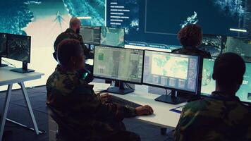 Army officer establishing new operating bases through a world map satellite vision, ensure the connectivity to the power base command center. Commander operates CCTV radar footage. Camera B. photo