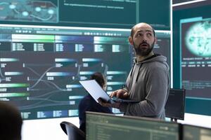 Hackers team engaging in governmental espionage and using phishing techniques for illegal access to data, working on national security breach. Spyware agency gains access on a big screen. photo