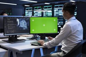 Programmer working on green screen computer in data center with artificial intelligence tech to process datasets. Employee solving tasks on mockup PC in server hub storing data used for deep learning photo