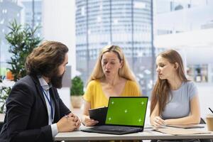 Financial advisor using green screen laptop to help family maintain budget, avoiding overspending. Agent in office using software on chroma key notebook to build emergency fund plan for clients photo