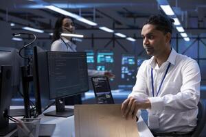 Data center professional developing emergency procedures to ensure company continuity in case of disaster or system failure. Man in server room ensuring compliance with industry regulations photo