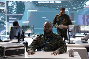 Military command center with soldier conducting a high security videoconference, coordinating real time intelligence for national defense and surveillance operations. Protect the nation. photo