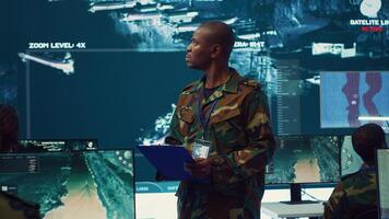 Navy captain oversees collecting important data for a national defense mission, targeting enemy vessels with the satellite radar system. Reconnaissance in a military base of operations. Camera A. photo