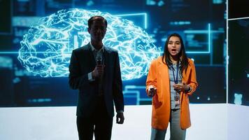 Tech specialists discussing during keynote summit presentation, exploring successful implementation of AI in driving forward businesses, sharing latest artificial intelligence innovations, camera A photo