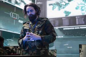 Army soldier reviewing information on a hologram projection in control center, creating a battlefield map for the infantry unit deployed. Serviceman monitoring surveillance system. photo