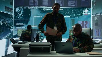 Intelligence agents in modern operations center managing surveillance activity and synchronizing security protocols. Army base staff interpret real time data to protect national interests. Camera B. photo