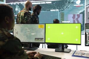 Woman engineer examining reconnaissance footage and chroma key display, works with satellite surveillance in command post. Female recruit uses green screen and radar CCTV imagery. photo