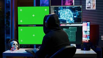 Hacker listening music while using isolated screen PC and AI to steal data. Scammer wearing headphones using artificial intelligence and mockup computer to compromise digital devices, camera A photo