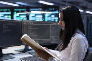 IT supervisor verifying data center infrastructure documentation paperwork, configurations and procedures. Server farm inspector reading performance benchmarks and conducting analysis photo