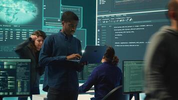 Group of governmental hackers analyzing digital threats on pc networks, using a big screen. Specialists working on collecting information, fighting against cybercrime and cyberterrorism. Camera A. photo