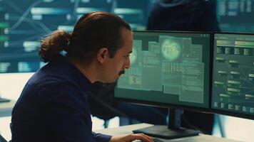 Governmental IT expert monitoring cyber threats on a computer and big screen, high tech agency office. Hackers examining cyber defense measures for prevention of dangerous digital threats. Camera A. photo