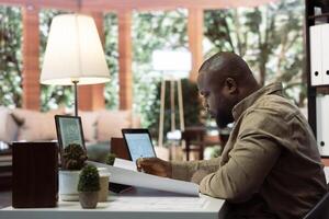 Corporate owner measuring and evaluating office blueprints and architectural sketches, working on strategy planning for a modern and professional workspace design. Relocate office space. photo