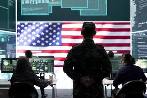 US army official working on ensuring servers protection and state secrets, protecting important hybrid warfare data in high tech agency office. Military soldier supervises hacking activity. photo
