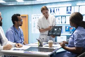 Team of specialists reviewing ecg results in a meeting at a private clinic, analyzing cardiovascular system on a radiography for disease prevention. Consulting cardiac scans and records. photo