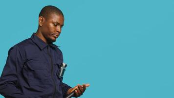 Security guard preventing criminal activity, threatening suspects with active bodycam. Portrait of menacing bodyguard pointing towards security body camera, studio background, camera A photo