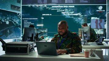 Army intelligence expert utilizes modern computer systems and satellite radar imagery to enhance national security, strategic initiatives and ensure defense in mission control center. Camera B. photo
