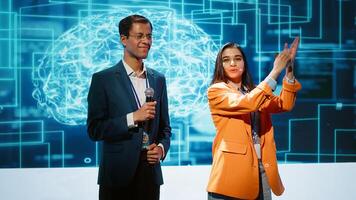 Tech startup managers offer latest AI services during tech summit. Businesspeople using mic to do presentation for business investors interested in artificial intelligence, camera A photo