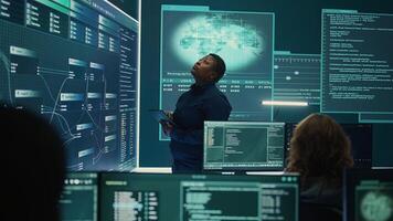 Professional IT expert working in a governmental security operations center, analyzing data on a big screen. Highlighting the importance of cyber security monitoring and threat analysis. Camera B. photo