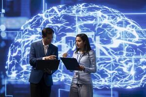 Team of engineers analyzing AI models with large digital brain displayed behind. IT staff members, using machine learning to better understand and develop artificial intelligence photo
