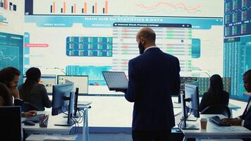 General director employing big data to help in solving tasks in control room, operating on huge screen to create a performance metrics analysis. Manager ensuring organizational efficiency. Camera B. photo