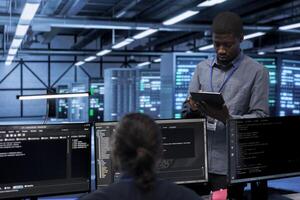 Engineer in data center running system diagnostic tests and error checking utilities to identify and resolve problems. Worker looking for network issues affecting server performance and connectivity photo