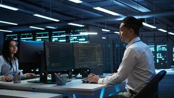 Engineer overseeing data center, making improvements and updates to ensure system can handle networking tasks, handheld camera shot. Indian man in server room tracking network traffic, camera B photo
