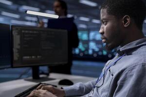 Computer scientist reconfiguring server room to optimize it for data processing requirements of customers. Programmer typing on PC, ensuring data center equipment operates efficiently, close up photo
