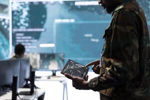 High tech military office with soldiers analyzing real time data, processing intelligence information and coordinating strategic operations to support army field missions effectively. photo