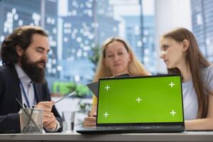 Financial advisor works with clients to create long term investment strategies, using green screen laptop. Agent helps family set realistic financial goals and roadmap using chroma key notebook photo