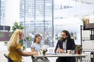 Financial advisor discussing with customers, recommending optimal insurance policies. Agent informing parent and daughter of best investment strategies, offering statistics photo