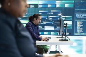 Governmental hackers performing a cyber attack simulation after studying the national database servers. Experts working on IT security, data breach prevention against ransomware. photo