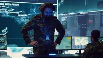 Infantry unit leader studies satellite imagery on a holographic image, working with high tech holograms to create the mission details for the troops. Ways to attack hostile vessels at sea. Camera A. photo