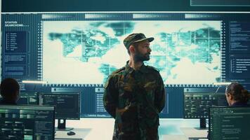 Military IT experts conducting surveillance and espionage activities using advanced technology and big screen. Governmental agency protecting against cyber threats and digital mercenaries. Camera B. photo