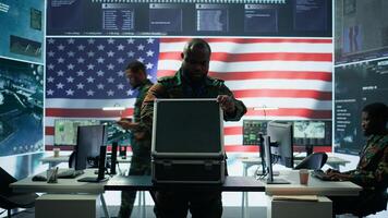 US military personnel work in a modern army command post, safeguarding classified information and state secrets against cyber attacks. Digital warfare and cybersecurity operations. Camera B. photo