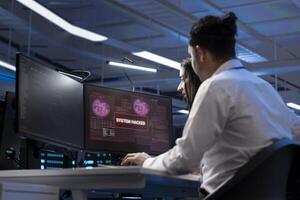 IT staff members in high tech facility trying to protect servers from hacker attack stealing sensitive information. Data center cybersecurity division coworkers protecting rigs during security breach photo