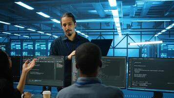 Manager supervising multiethnic team working in data center ensuring optimal performance. Supervisor and employees monitoring energy consumption across server rigs components photo