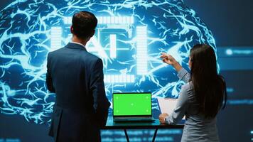 AI developers using isolated screen device for business data analysis. IT department staff members work on chroma key notebook to automatize tasks using artificial intelligence, camera A photo