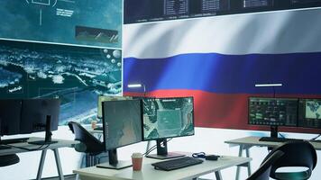 Empty mission control center with the russian flag on big screen, dealing with fake news and a terrorist attack with high tech gear. Spreading misinformation and controlling the people. Camera B. photo