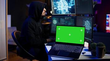 Isolated screen laptop used by cybercriminal in underground hideout to write lines of code and malware scripts. Mockup notebook used by evil programmer in hidden bunker, close up shot, camera B photo