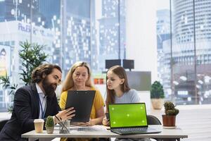 Financial advisor uses isolated screen laptop and tablet to help clients manage diversified investment portfolio. Agent uses chroma key notebook to provide family mix of stocks, bonds and other assets photo