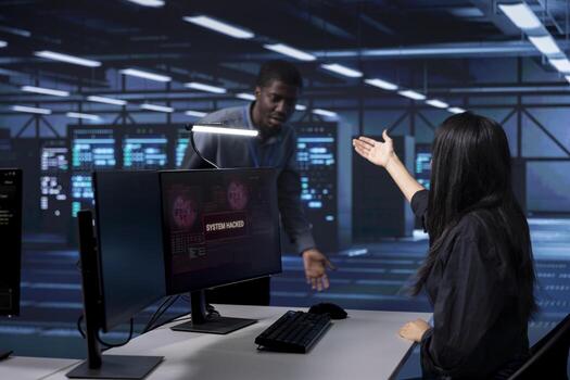 Woman in server farm calling coworker for help, trying to protect gear from hacker stealing information. IT professional in data center requesting assistance to fix security breach alert photo