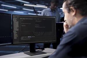 IT specialist reconfiguring server room to optimize it for data processing requirements of customers. Programmer coding, ensuring data center equipment operates efficiently photo