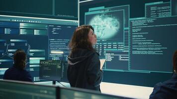 Hackers team engaging in governmental espionage and using phishing techniques for illegal access to data, working on national security breach. Spyware agency gains access on a big screen. Camera B. photo